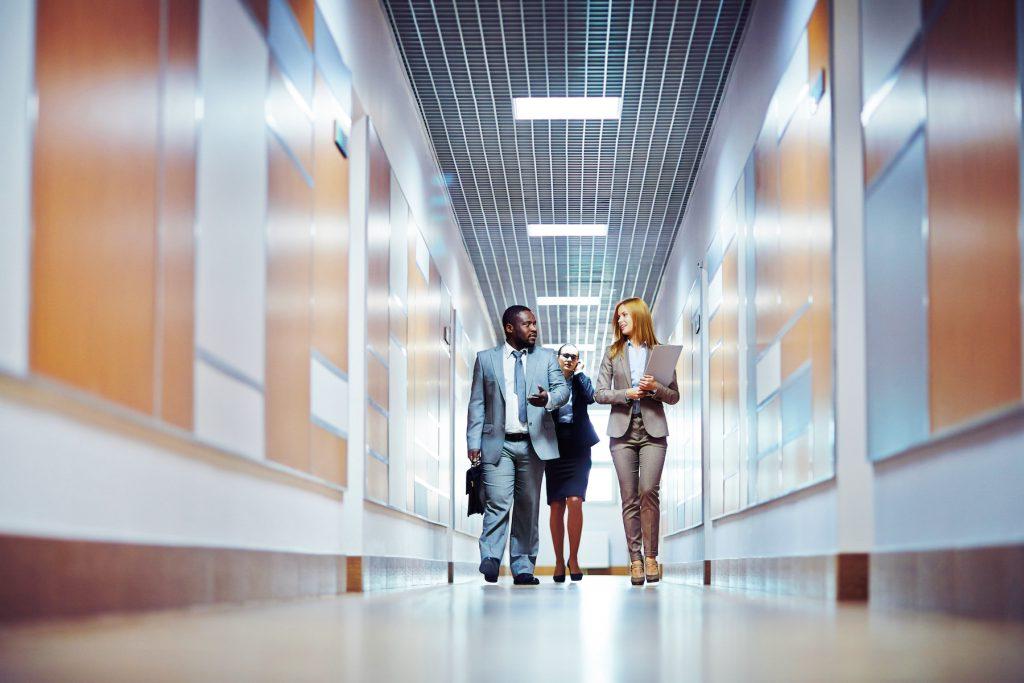 Business people walking down the office corridor and communicating